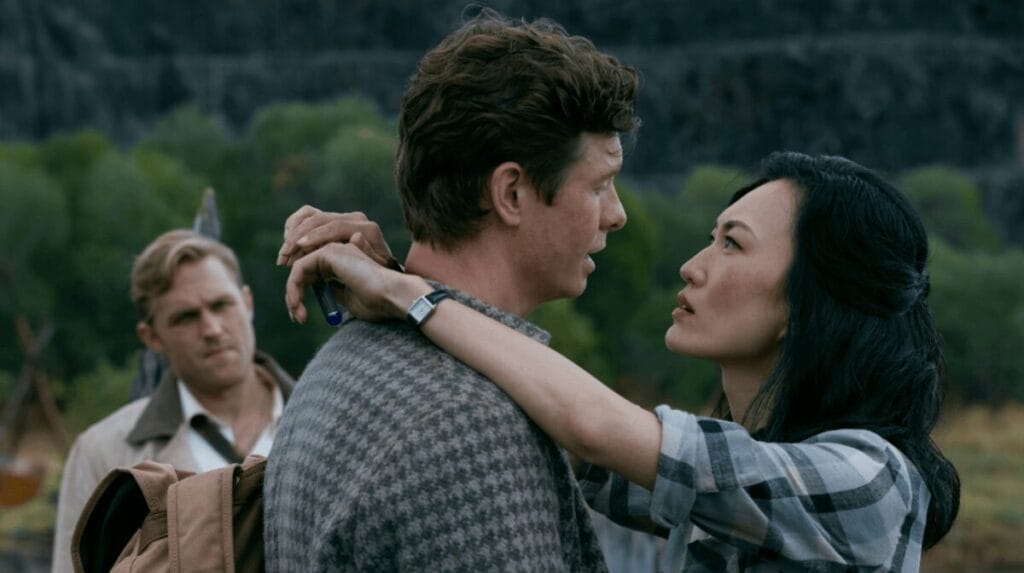 Keiko Miura berpelukan erat dengan Bill Randa dengan Lee Shaw memperhatikan dari belakang, membentuk segitiga cinta dalam garis waktu 1950-an MONARCH: LEGACY OF MONSTERS Season 2.