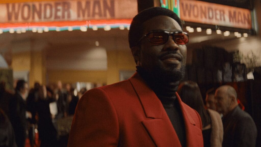 Yahya Abdul-Mateen II berjalan di karpet merah Hollywood sebagai bintang film Simon Williams dengan kamera menyorot wajahnya di film MARVEL's WONDER MAN yang hanya bisa disaksikan di Disney+.