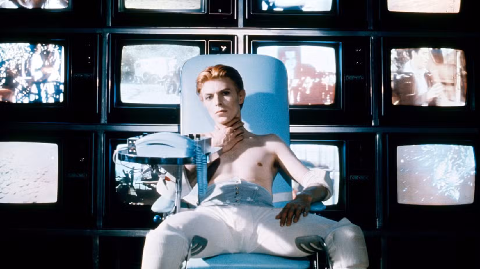David Bowie sitting in a chair as Thomas Jerome Newton in The Man Who Fell to Earth