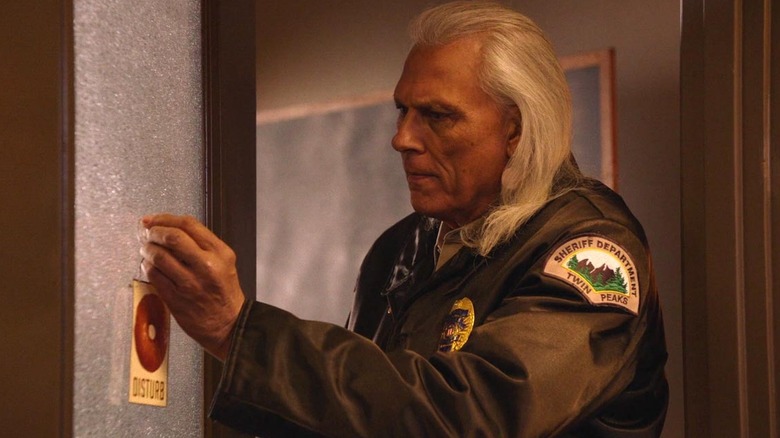 Deputy Hawk (Michael Horse) putting a sign on a door in Twin Peaks: The Return