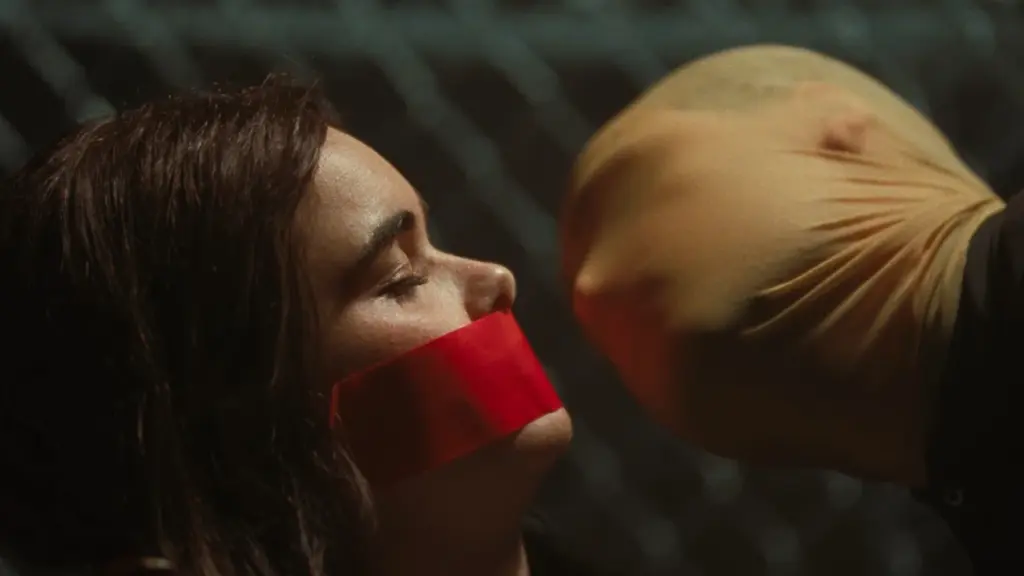 Barbie Ferreira terikat dan ditutup mulutnya dengan kain merah sementara Dacre Montgomery mengenakan masker ski mendekatkan wajahnya di FACES OF DEATH (2026).