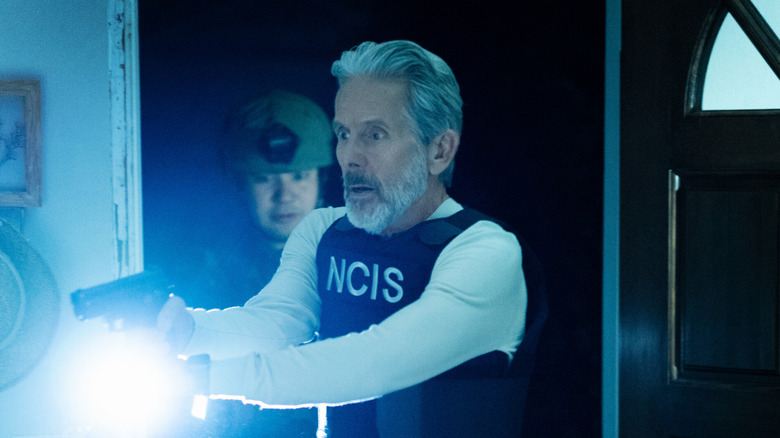 Alden Parker (Gary Cole) holding a gun and flashlight, looking shocked, on 'ncis.'