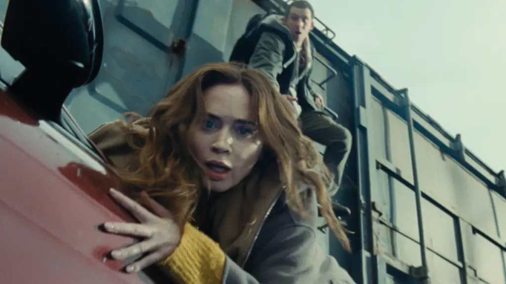 Emily Blunt almost falls off a car crashing into a moving high-speed train but is saved by Josh O'Connor in a thrilling action set pieces from DISCLOSURE DAY.
