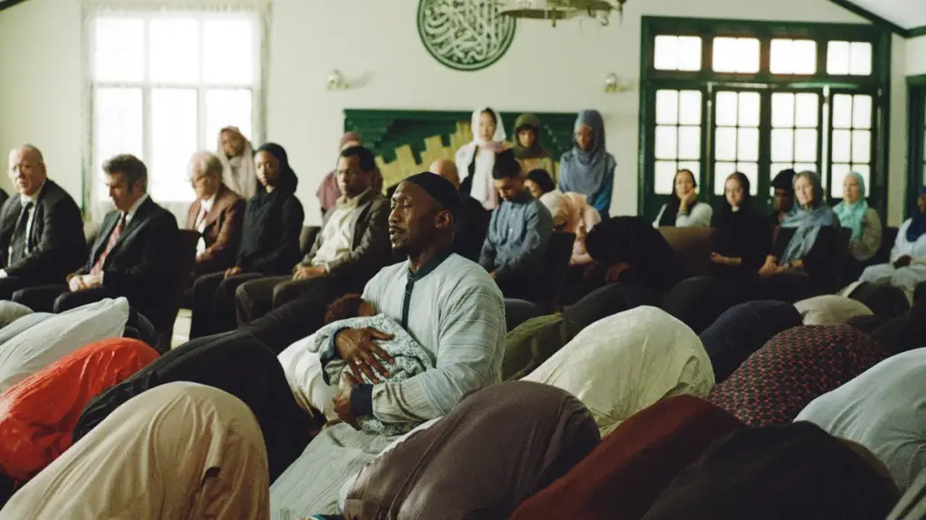 Mahershala Ali berdoa di dalam masjid yang dipenuhi jamaah sambil menggendong anaknya dengan penuh perasaan di YOUR MOTHER YOUR MOTHER YOUR MOTHER.