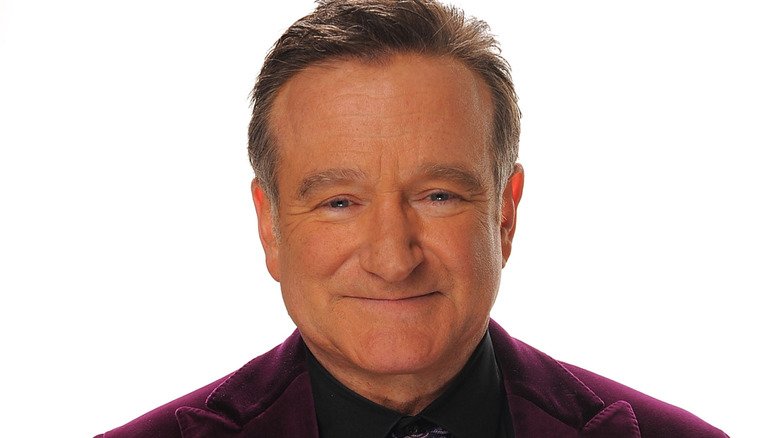 Robin Williams berpose saat mengenakan jas ungu.